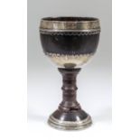 A late 17th/early 18th Century English silvery metal mounted coconut cup on turned walnut stem, 7ins