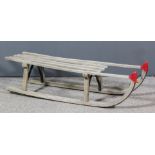 A wood and metal reinforced sledge, 39.5ins x 12.75ins x 11ins high