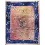 A Chinese carpet woven in navy blue, pale blue, and ivory with floral sprigs on a plain fawn ground,