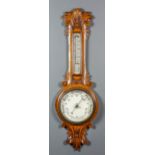 A late Victorian oak cased aneroid barometer and thermometer, the 7.25ins diameter white dial, in