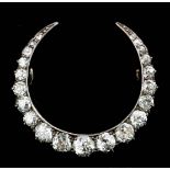 A late Victorian gold and silvery metal mounted all diamond set crescent pattern brooch, the