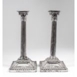 A pair of plated pillar candlesticks with cast Corinthian capitals and stop fluted columns, the