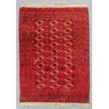 A Turkman Saryk rug woven in navy blue, brown, rose and ivory, three rows each of ten guls and
