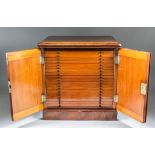 A late 19th Century mahogany coin collectors table cabinet, the paired doors with recessed arched