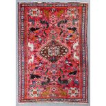 A Qashqai rug woven in colours with central lozenge-shaped medallion, bold animals and floral filled