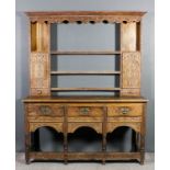 A 19th Century oak dresser, the whole later carved with leaf scroll and floral ornament, the upper