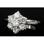 A modern 18ct white gold mounted all diamond set flowerhead pattern ring,the seven brilliant cut
