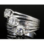 A modern silvery coloured metal mounted diamond set three stone crossover ring, each brilliant cut