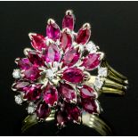 A modern 14ct gold mounted ruby and diamond dress ring of flowerhead design, the face set with