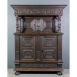 An old Dutch dark stained panelled oak court cupboard, the upper part with deep moulded