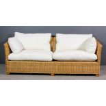 A modern wicker two-seat settee of large proportions, on square feet, 78ins wide, and loose squab