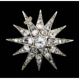 A late Victorian gold coloured metal mounted all diamond set twelve point star pattern brooch, the