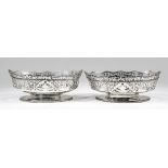 Two pierced George V silver oval bowls, the shaped rims with bead mounts, the sides pieced with