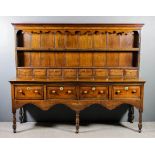 An 18th Century panelled oak dresser base with later upper part with moulded cornice and shaped