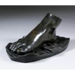 A 19th Century dark brown patinated bronze paperweight modelled as a human foot, 3.5ins high