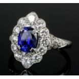 A modern silvery coloured metal mounted sapphire and diamond ring, the central oval cut sapphire