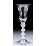 An 18th Century wine glass with plain bell-shaped bowl and quadruple knopped air twist stem, on