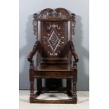 A good 17th Century panelled oak "Wainscot" armchair, with bold shaped and carved scroll pattern