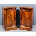 A pair of George IV figured mahogany pedestal cupboards with square top edges, one fitted with an