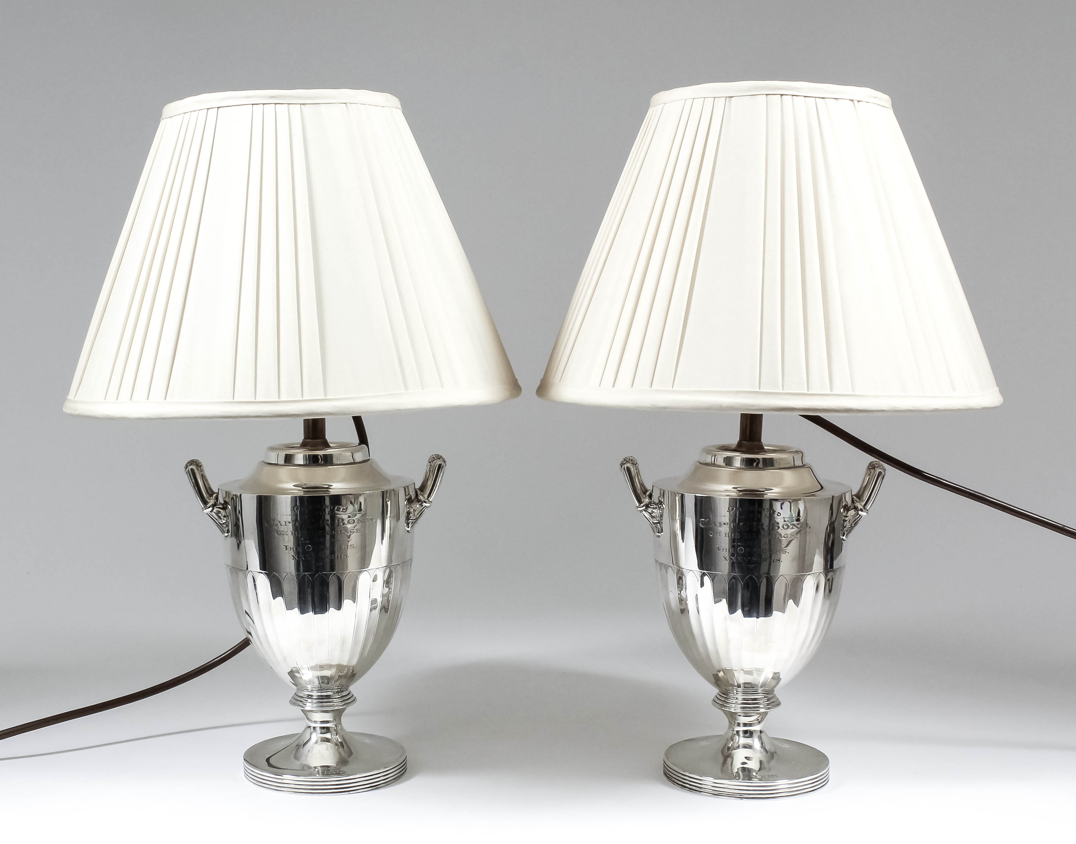 A pair of late Victorian silver two-handled urn pattern table oil lamps (now converted to