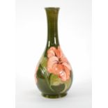 A WALTER MOORCROFT POTTERY SLENDER BOTTLE SHAPE VASE, the green ground with tube lined pink flowers,