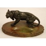 AN EARLY TWENTIETH CENTURY JAPANESE STYLE 'BRONZED' WHITE METAL MODEL TIGER UPON AN OVAL ONYX BASE