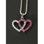 RUBY AND DIAMOND SET 18CT WHITE GOLD DOUBLE HEART PENDANT, set with 22 round cut rubies and 18 round