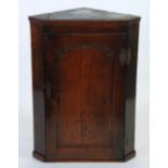 LATE EIGHTEENTH CENTURY OAK FLAT FRONTED CORNER CUPBOARD, the simple moulded cornice above a