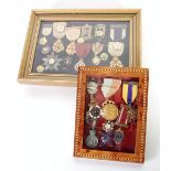 FRAMED AND GLAZED COLLECTION OF GILT METAL AND MAINLY YELLOW ENAMEL MEDALLIONS AND BADGES RELATING