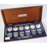 BOXED SET OF TWELVE SHIELD SHAPED SILVER MEDALLIONS 'THE ROYAL ARMS' to commemorate Queen