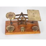PAIR OF EARLY TWENTIETH CENTURY BRASS POSTAL SCALES,  of conventional design on an oak base,