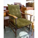 AN EARLY TWENTIETH CENTURY OAK RECLINING ARMCHAIR, WITH BOBBIN TURNED FRONT SUPPORTS, LOOSE BACK AND