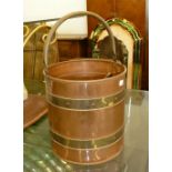 A COPPER AND BRASS BANDED CIRCULAR BUCKET WITH OVERHEAD HANDLE, THE CONTENTS OF VARIOUS BRASS AND