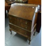 A WALNUT BUREAU WITH THREE LONG DRAWERS, ON CABRIOLE SUPPORTS