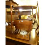 AN OAK OVAL COFFEE TABLE AND PERIODICAL RACK COMBINED AND AN ANEROID BAROMETER IN A CARVED OAK