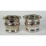 A PAIR OF LATE VICTORIAN/EDWARDIAN PLATED ON COPPER PIECED WINE BOTTLE HOLDERS, with stamped foliate