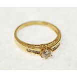 SOLITAIRE DIAMOND RING, claw set round brilliant cut diamond 0.28ct approx., channel set shoulders
