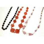 RED AND WHITE STRIPED MOULDED GLASS BEAD NECKLACE, A BLACK GLASS BEAD NECKLACE, THREE CRYSTAL BEAD