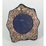 VICTORIAN STYLE SILVER FRONTED PHOTOGRAPH FRAME, shaped circular form, embossed with putti and c-