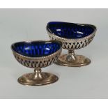 PAIR OF SILVER OPEN SALTS, pierced oval form, with bell husk borders and pedestal bases, with blue