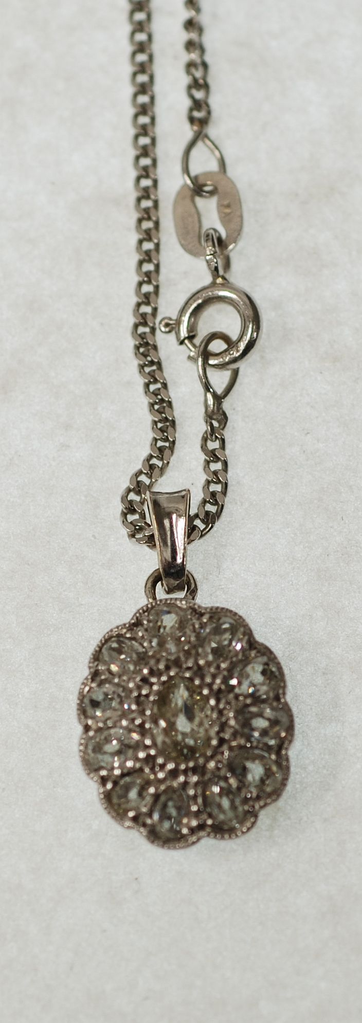DIAMOND SET CLASP, CONVERTED TO A PENDANT, milgrain set with central pear cut diamond with a