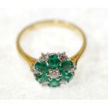 EMERALD AND DIAMOND CLUSTER RING, claw set with six oval mixed cut emeralds and seven round