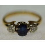 SAPPHIRE AND DIAMOND SET RING, oval mixed cut sapphire flanked by two round brilliant cut
