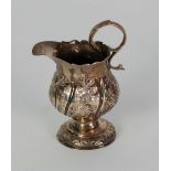 GEORGE III SILVER PEDESTAL CREAM JUG, with acanthus capped flying scroll handle and later foliate