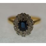 SAPPHIRE AND DIAMOND CLUSTER RING, oval cut sapphire with surround illusion set with ten single