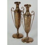 PAIR OF EDWARDIAN WEIGHTED SILVER SLENDER URN SHAPED VASES, with double scroll handles, on