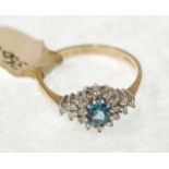 A 9ct GOLD TINY DIAMOND AND BLUE STONE SET RING, the centre blue stone within a surround of eighteen