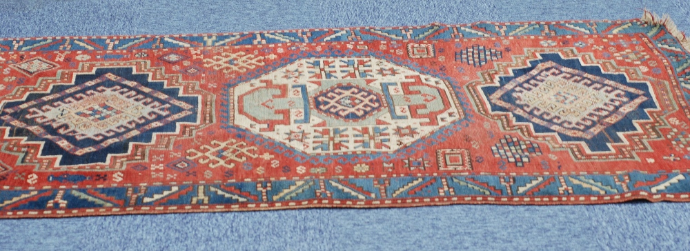 ANTIQUE N.W. PERSIA/CAUCASIAN WOLL PILE RUG, the brick red field with three medallions within a