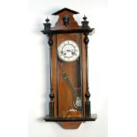 A SMALL LATE 19TH CENTURY GERMAN WALNUT AND PARCEL EBONISED SPRING DRIVEN WALL CLOCK