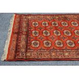 MACHINE MADE 'BOKHARA' RUG, with three rows of guls on a crimson field, 6'3" x 4'5" and an EASTERN